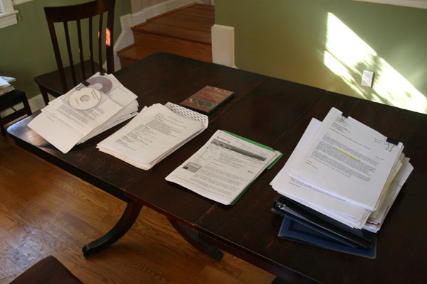 Table avec quatre piles de papiers en attente d'être assemblés en paquets de demande